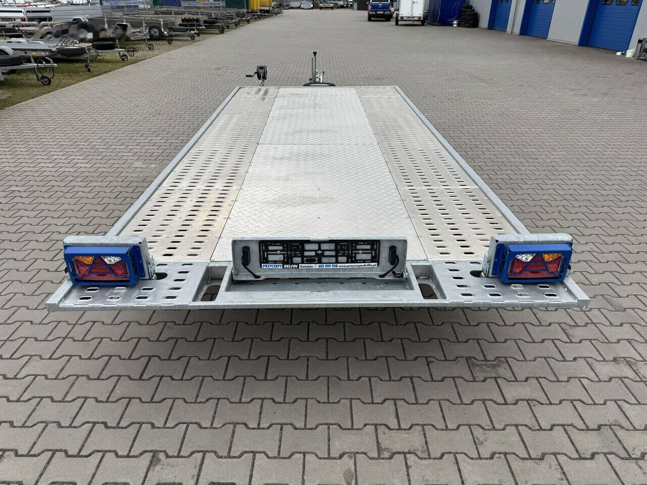 Platformă auto pentru transport vehicule, parcare exterioară.